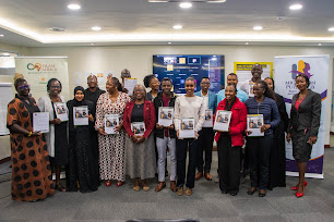 A larger group of launch participants holding copies of the report